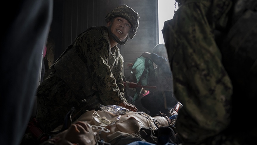U.S. Navy Hospital Corpsman 2nd Class Maliq Webster, assigned to the Whidbey Island-class dock landing ship USS Rushmore, performs critical medical care on a simulated patient during a tactical combat casualty care training exercise at Yokota Air Base, Japan, on April 3, 2025. Facilities on Yokota can recreate maritime-specific environments through training elements like smoke effects and low-light conditions, which provide sailors with realistic, shipboard-relevant training. (Photo by U.S. Air Force Senior Airman Samantha White)